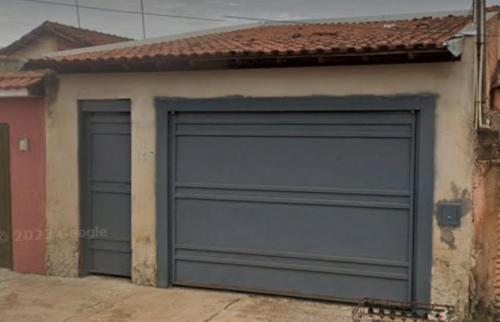un garage avec deux portes de garage sur une maison dans l'établissement Quarto para Agrishow, à Ribeirão Preto