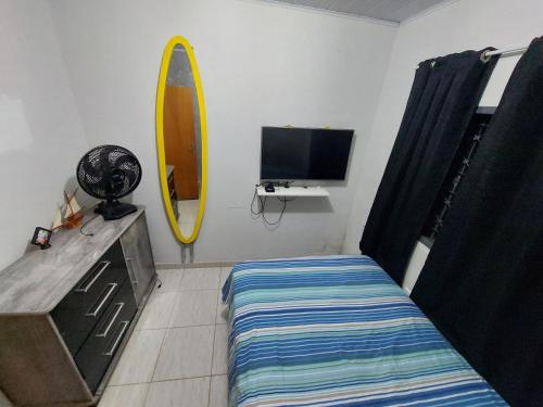 1 dormitorio con cama y tabla de surf en la pared en Quarto para Agrishow, en Ribeirão Preto