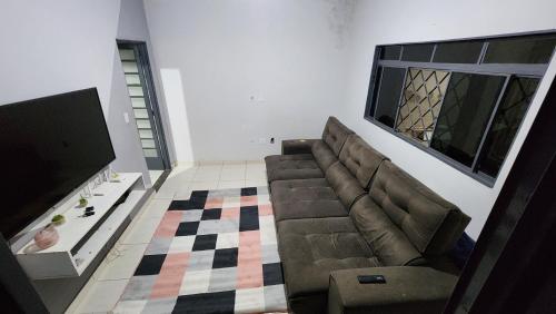 uma sala de estar com um sofá e um piso em xadrez em Quarto para Agrishow em Ribeirão Preto