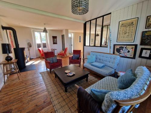 a living room with couches and chairs and a table at Holiday Home Locquirec by Sandy Beach in Locquirec