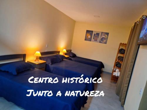 a hotel room with two beds and the words caffe museo tinto a warehouse at Suítes Recanto Petrópolis in Petrópolis