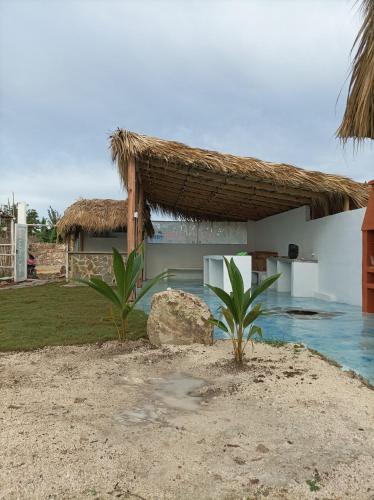 uma casa com telhado de palha e um quintal em Blue Beach Eco-Hotel by Sanfabini em Bayahibe