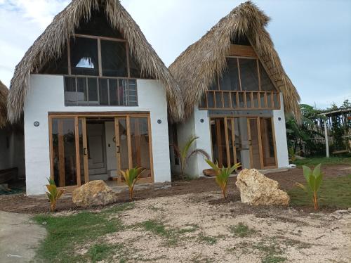 uma casa com duas cabanas de palha e duas pedras em Blue Beach Eco-Hotel by Sanfabini em Bayahibe
