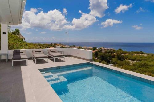 a swimming pool with a view of the ocean at NEW Amazing Villa with Sea Views-Walk to Beach-8 guests-Private Pool in Willibrordus