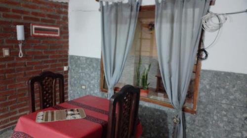 a room with a table and a window with curtains at Departamento Ayllu III in Tilcara