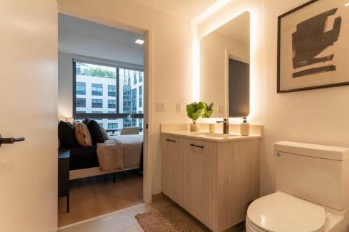 a bathroom with a toilet and a sink and a bedroom at Wynwood Luxury & Modern Apt in Miami