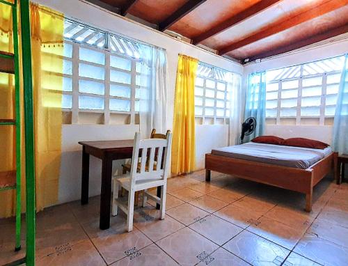 a bedroom with a bed and a table and window at Arana House in Puerto Viejo
