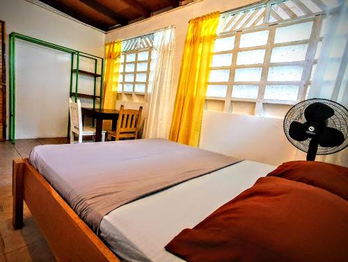 a bedroom with a bed with a fan and a window at Arana House in Puerto Viejo