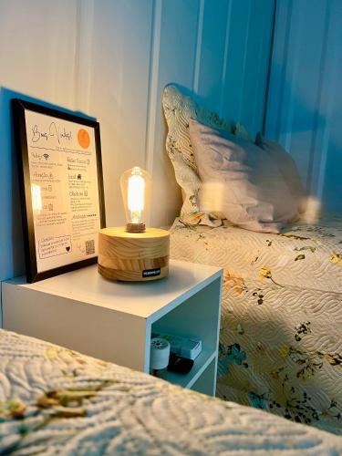 a bedroom with a bed with a lamp on a night stand at Container Suítes Recanto Monte Trigo in São Francisco do Sul