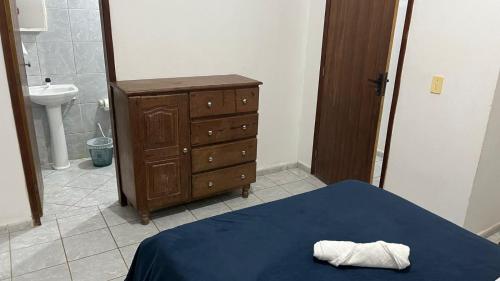 a bedroom with a bed and a dresser and a sink at Condomínio Enseada dos Corais apto completo in Cabo de Santo Agostinho