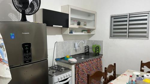 a small kitchen with a sink and a refrigerator at Condomínio Enseada dos Corais apto completo in Cabo de Santo Agostinho