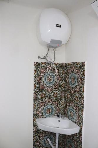 a bathroom with a sink and a light on a wall at Taghazout Flats in Taghazout