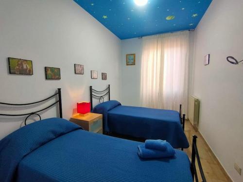 een slaapkamer met 2 bedden en een blauw plafond bij Casa a Matrice a Barrafranca in Barrafranca
