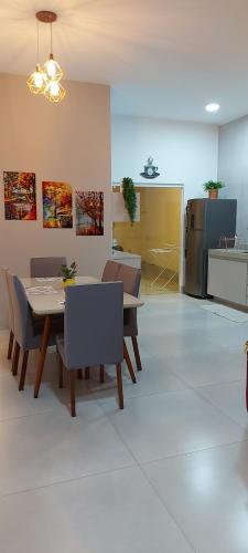 a dining room with a table and chairs and a kitchen at Casarosegolds in Uberlândia