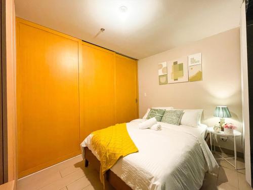 een slaapkamer met een groot bed en een gele kast bij Deluxe 1br - Bgc Uptown - Netflix, Pool #oursw7b2 in Manilla