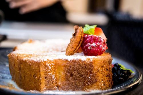 a piece of cake with fruit on top on a plate at Casa Tavera- Adults Only in Mérida
