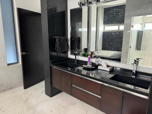 a bathroom with a sink and a large mirror at Casa en el CID DE MAZATLÁN, SINALOA in Mazatlán