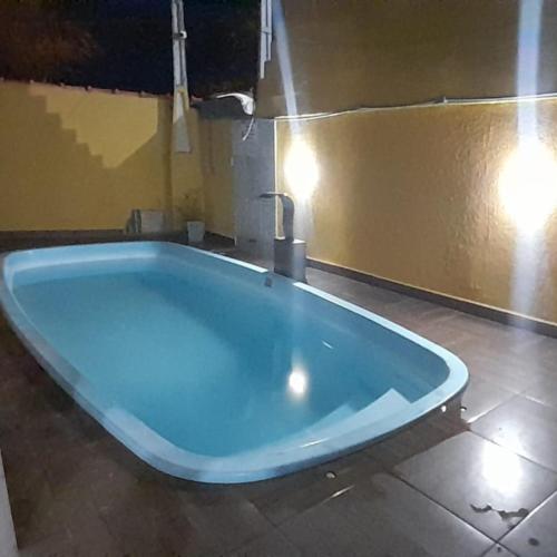 Una gran bañera azul con grifo en un baño. en Hostel Sorocabana Beach, en Itanhaém