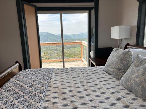 a bedroom with a bed and a large window at Mystic Mountain Retreat in Miramonte