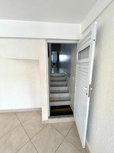 a hallway with a stairway leading to a door with a stair at Casa Ampla - Ótima Localização in Piracicaba