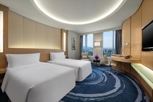 a hotel room with two beds and a desk at Shenzhen Futian Crowne Plaza Hotel,Near by Futian Station and Coco Park, Outdoor Heated Pool in Shenzhen