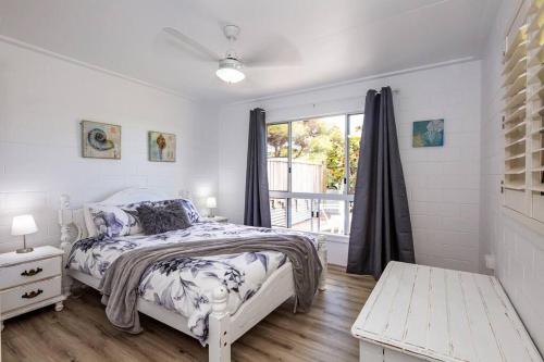 ein weißes Schlafzimmer mit einem Bett und einem Fenster in der Unterkunft Puppies&Pancakes at Innes Park Opp Park&Beach Dogs welcome inside in Pemberton