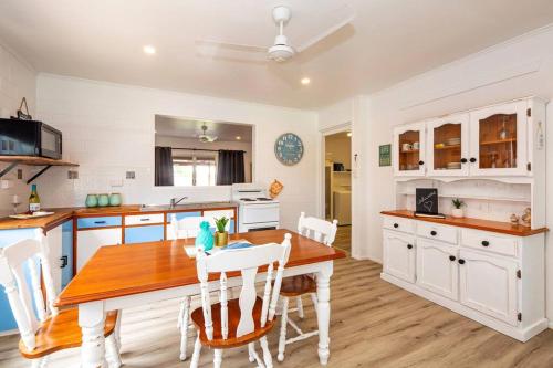 eine Küche mit einem Holztisch und weißen Schränken in der Unterkunft Puppies&Pancakes at Innes Park Opp Park&Beach Dogs welcome inside in Pemberton