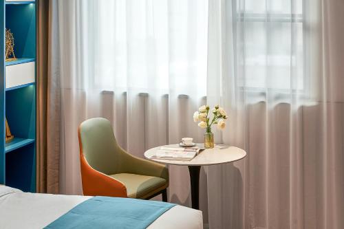 a room with a table and a chair and a window at 珠海海之珠丨Global Romantic Pearl酒店-拱北口岸珠海站店 in Zhuhai