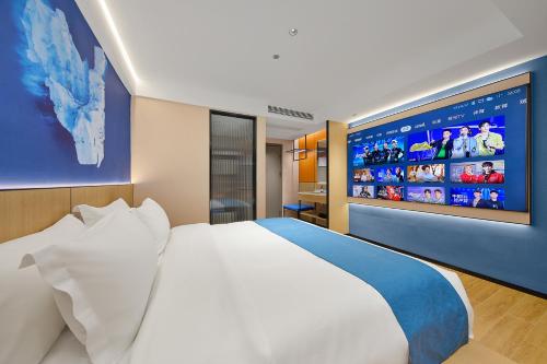 a bedroom with a large white bed and a large screen at 珠海海之珠丨Global Romantic Pearl酒店-拱北口岸珠海站店 in Zhuhai