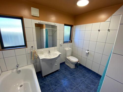 uma casa de banho com um WC, um lavatório e uma banheira em Pohara Tides - Poharas Beach Getaway em Pohara