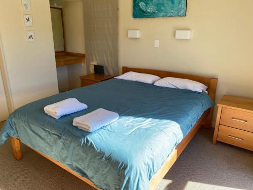 a bedroom with a bed with two towels on it at Pohara Tides - Poharas Beach Getaway in Pohara