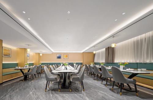 a restaurant with tables and chairs in a room at Pearl Hotel - Gongbei Port Zhuhai in Zhuhai