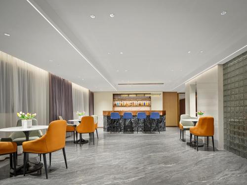 a lobby with tables and chairs and a bar at 珠海海之珠丨Global Romantic Pearl酒店-拱北口岸珠海站店 in Zhuhai