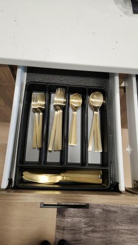 a set of forks and spoons in a drawer at Cozy King Suite in the heart of Towson in Towson
