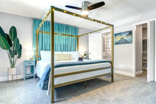 1 dormitorio con cama con dosel y cortinas azules en Heated Pool, near Beach,USSSA, Patrick Space Force,FIT, en Melbourne