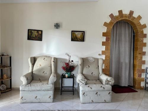two chairs sitting in a living room with a window at قرية الفيروز الساحل الشمالي El Fairouz Village north coast in Qaryat Shurūq