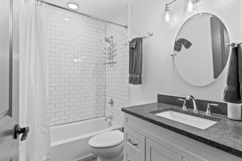 La salle de bains est pourvue d'un lavabo, de toilettes et d'un miroir. dans l'établissement Lux Riverfront Loft-Parking-WD-P201, à Saint-Louis