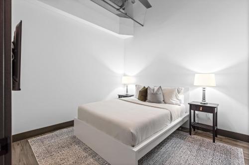 - une chambre blanche avec un lit et deux lampes dans l'établissement Lux Riverfront Loft-Parking-WD-P201, à Saint-Louis
