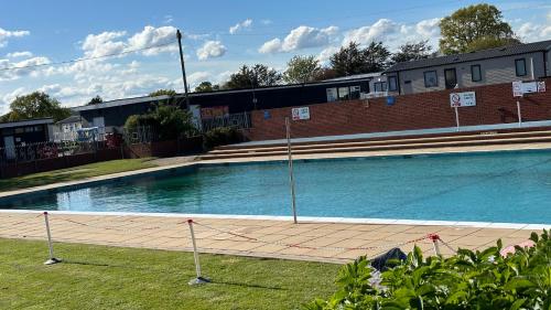 a large swimming pool in front of a brick building at Getaway House in Clacton-on-Sea