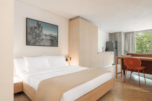 Habitación de hotel con cama, escritorio y cocina en Nido Parque Mexico, en Ciudad de México