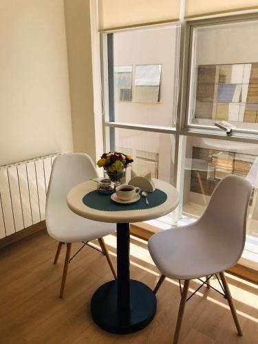 a table and chairs in a room with a window at FRATELLI CORP APART HOTEL in La Paz