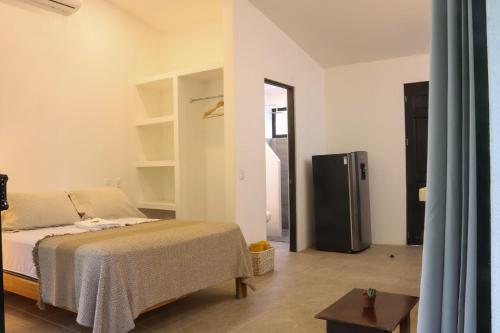 a bedroom with a bed and a refrigerator at Vista Verde Surf & Studios - jungle View in Carmen