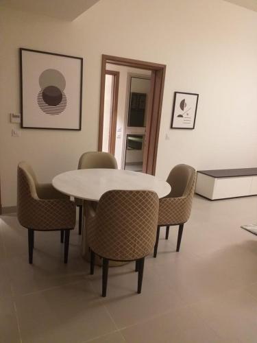 a dining room with a white table and chairs at Address marassi resort in El Alamein