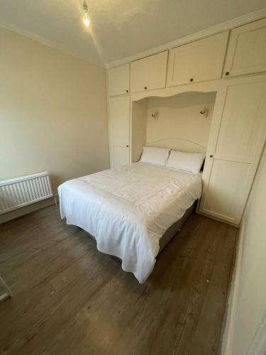 NKY CRYSTAL 4 Bed House Apartment في لندن: غرفة نوم مع سرير أبيض كبير في غرفة