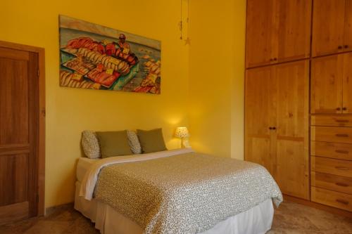 a bedroom with a bed and a painting on the wall at Quinta Estrella in Valle de Guadalupe