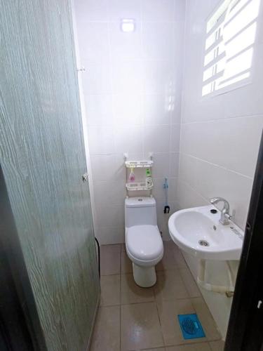 Un baño pequeño con inodoro y lavabo. en HomeSTAY TAMAN MANJUNG POINT LUMUT PERAK, en Lumut