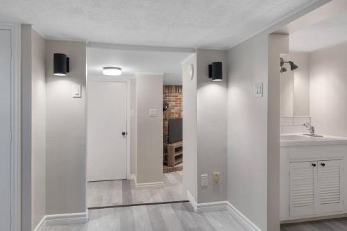 a white kitchen with a sink and a counter at Chic House with King Bed, Walk To Dining and Starbucks in Dieppe