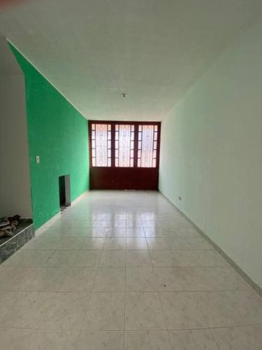an empty room with green walls and a large window at Casa amplia con garaje in Fusagasuga