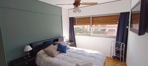 a bedroom with a bed and a large window at Departamento en peatonal, centro de Mendoza!! in Mendoza