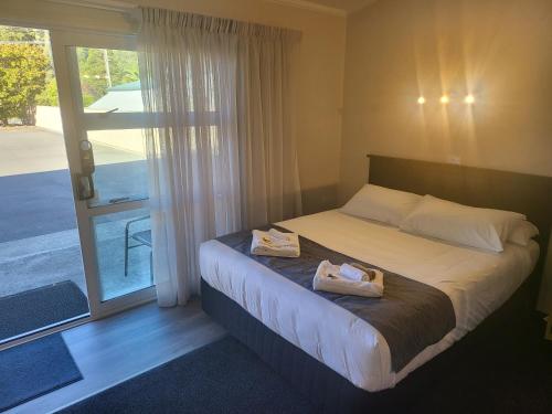 een slaapkamer met een bed met twee handdoeken erop bij Ferrylink Motel in Picton